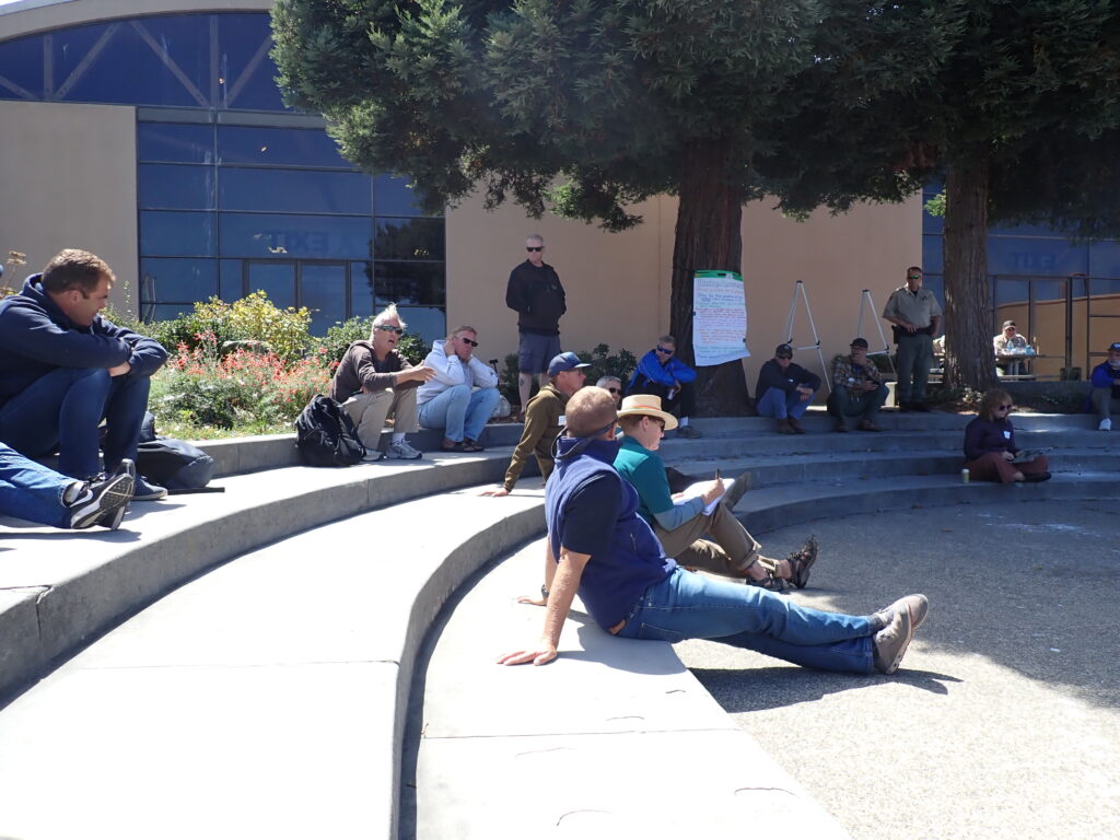 Image showing people sitting in the open-air amphitheater listening to the speaker at the alternative gear workshop